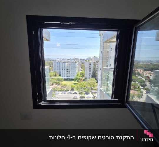 חלון אלומיניום פתוח עם נוף לעיר